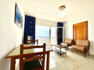 een woonkamer met een eettafel en stoelen bij Apt next to the Atlantic Ocean, with unbeatable views in Tamaduste