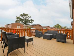 a deck with wicker chairs and tables on it at Number 54 in Stowmarket