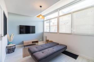 a living room with a couch and a flat screen tv at Spacieux T2 proche plages côte de granite rose in Trébeurden