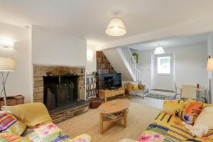 uma sala de estar com um sofá e uma lareira em Lilac Cottage em Parkend