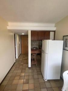 uma cozinha com um frigorífico branco e uma mesa em Ondina Apart Hotel - Apto 419 em Salvador
