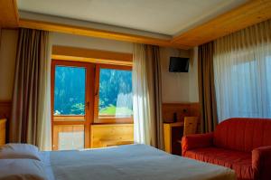 a hotel room with a bed and a window at Albergo Serena in Auronzo di Cadore