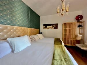 a bedroom with a large bed and a chandelier at Libelle in Granada