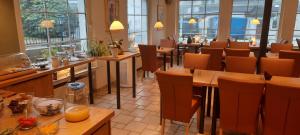 a restaurant with tables and chairs and windows at Hotel zum Kreuzberg in Winterberg +79 photos