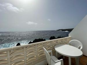 einen Balkon mit einem Tisch, Stühlen und Meerblick in der Unterkunft Apt next to the Atlantic Ocean, with unbeatable views in Tamaduste