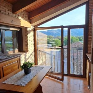 a kitchen with a table and a balcony with a view at Tranquilo apartamento vistas al Mondalindo 