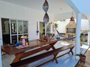 - une table en bois sur une terrasse avec un hamac dans l'établissement Casa com piscina 300 M Broadway Canoa quebrada, à Canoa Quebrada