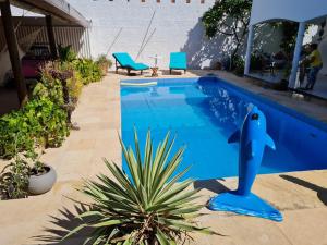 - une piscine avec une statue de dauphins dans une cour dans l'établissement Casa com piscina 300 M Broadway Canoa quebrada, à Canoa Quebrada