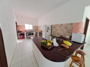 - une cuisine avec un comptoir et un bol de fruits dans l'établissement Casa com piscina 300 M Broadway Canoa quebrada, à Canoa Quebrada