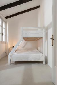 białe łóżko piętrowe w białym pokoju w obiekcie Charming loft in Venetian Villa w mieście Noale