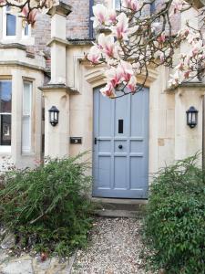 una puerta azul en un edificio con flores rosas en A spacious 1 bedroom in an historic building en Newbury