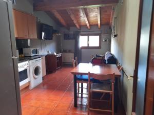 uma cozinha com mesa e uma cozinha com fogão e micro-ondas em Apartament Gran Pirineu em Montferrer