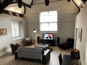 a living room with a couch and a tv at A spacious 1 bedroom in an historic building in Newbury