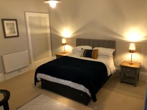 ein Schlafzimmer mit einem großen Bett mit zwei Tischen und zwei Lampen in der Unterkunft A spacious 1 bedroom in an historic building in Newbury