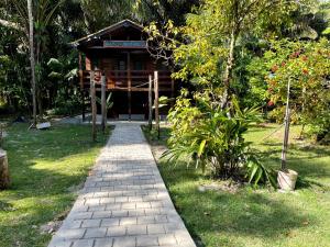 a brick path leading to a building in a garden at Casa da mata marajó in Salvaterra