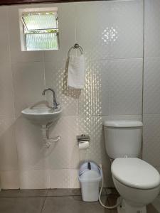 biała łazienka z toaletą i umywalką w obiekcie Casa da mata marajó w mieście Salvaterra