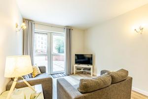 a living room with a couch and a tv at Cotels at Centro Serviced Apartments in Northampton