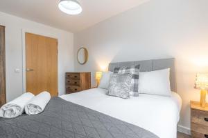 a bedroom with a large bed with towels on it at Cotels at Centro Serviced Apartments in Northampton