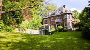 a large brick house on a lush green lawn at Guest house La Maison Chantecler in Brussels