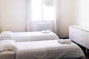 Dos camas en una habitación blanca con toallas. en Centro Città City Suite, en Bari