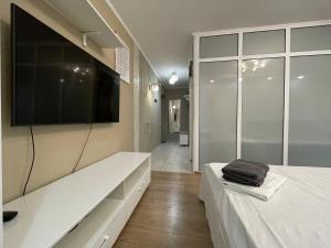 a bedroom with a large tv on the wall at Квартира с гостиничным сервисом бизнес-класса с большой ванной и Smart-TV in Petropavlovsk