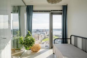 Fabulous Morden Apartment in Helsinki في هلسنكي: غرفة نوم بسرير ونوافذ كبيرة