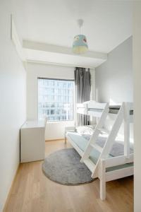 a white bedroom with a bunk bed and a window at Fabulous Morden Apartment in Helsinki in Helsinki