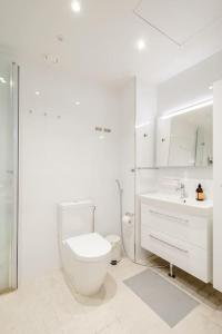 biała łazienka z toaletą i umywalką w obiekcie Fabulous Morden Apartment in Helsinki w Helsinkach