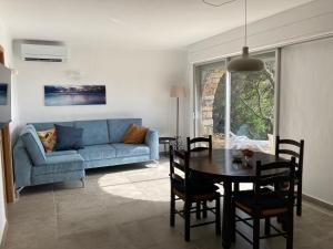 un salon avec un canapé bleu et une table dans l'établissement Belle Vue de Fogata, à Corbara 15 autres photos