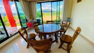 a dining room with a wooden table and chairs at ภูระเริงวิลล่า วังน้ำเขียว Phu Raroeng Villa in Ban Khlong Ki