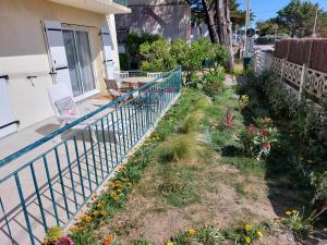 ein Garten an der Seite eines Hauses mit Blumen in der Unterkunft CHARMANT APPARTEMENT en BRETAGNE, PROCHE La BAULE et GRANDE PLAGE, 4 ETOILES in Batz-sur-Mer