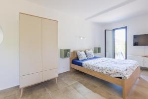 ein Schlafzimmer mit einem Bett und einem großen weißen Schrank in der Unterkunft Petite Pause de Fogata - Jolie vue mer in Corbara