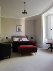 a bedroom with a bed and a red couch at A spacious 1 bedroom in an historic building in Newbury
