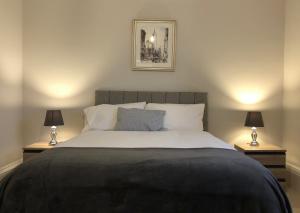 A spacious 1 bedroom in an historic building في نيوبري: غرفة نوم بسرير كبير فيها مصباحين