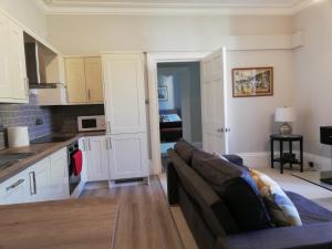 a living room with a couch and a kitchen at A spacious 1 bedroom in an historic building in Newbury