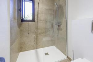 eine Dusche mit Glastür im Bad in der Unterkunft Petite Pause de Fogata - Jolie vue mer in Corbara