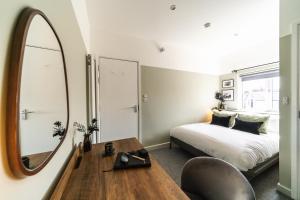 a bedroom with a bed and a mirror at Urban Oasis by Keystone in Newport
