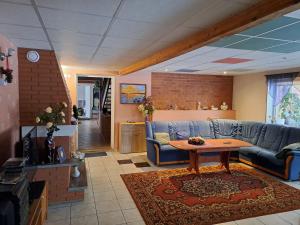 a living room with a blue couch and a table at Rähni Maja in Põlva