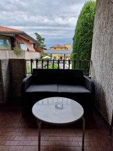 ein schwarzes Sofa und einen Tisch auf einer Terrasse in der Unterkunft Residenza Marisa in Sirmione