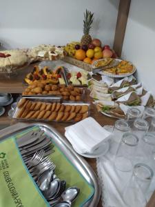 a table topped with plates of food and silver spoons at Senior Parque Hotel in Santa Rosa