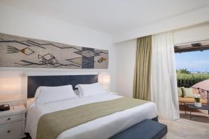 a bedroom with a large bed and a window at Hotel Abi d'Oru in Porto Rotondo