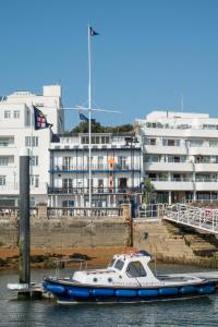 ein im Wasser neben einem Gebäude angedocktes Boot in der Unterkunft Royal London Yacht Club in West Cowes