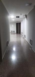 an empty room with white walls and a hallway with paintings at Kobaladze Apartments in Batumi