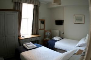 a hotel room with two beds and a window at Royal London Yacht Club in West Cowes