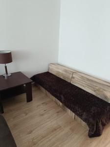 Cama grande de madera en habitación con mesa en Veľký Apartmán 2-4 osôb v srdci Tatier, en Liptovský Hrádok