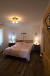a bedroom with a large bed and two night stands at Borgo Don Camillo in Cutigliano