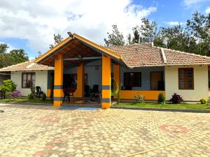 ein kleines Haus mit einem gelben in der Unterkunft STAYMAKER Siri Vismaya Home Stay in Chikmagalur