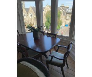 a table and chairs in a room with a window at Edradour in St. Andrews