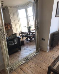 a large mirror in a living room with a table at Edradour in St. Andrews