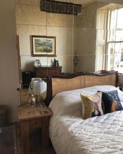 a bedroom with a bed and a table with a lamp at Edradour in St Andrews